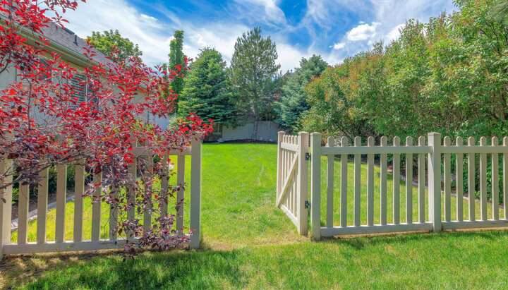 A functional fence gate providing access to a well-maintained backyard, surrounded by a wooden fence in Sarasota